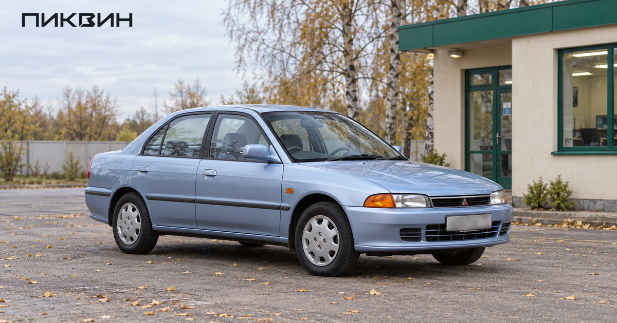 Обычный Mitsubishi Lancer поколения 1995 года без спортивного обвеса на открытой площадке.