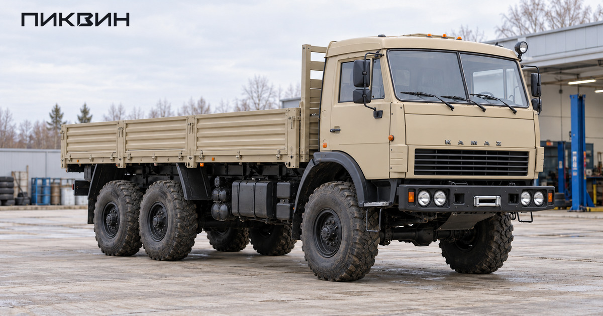 Трёхосный КамАЗ-53501 с односкатными колёсами и длинной бортовой платформой на сервисной площадке.