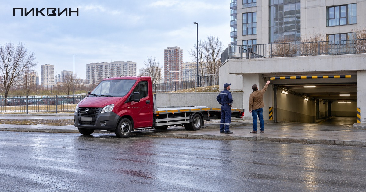 Владелец показывает специалисту низкий въезд в паркинг, эвакуатор стоит снаружи.