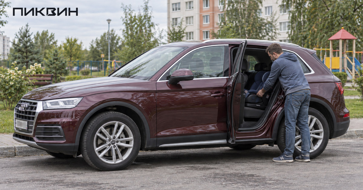 Мужчина проверяет крепление детского кресла на заднем ряду бордовой Audi Q5L через открытую дверь.