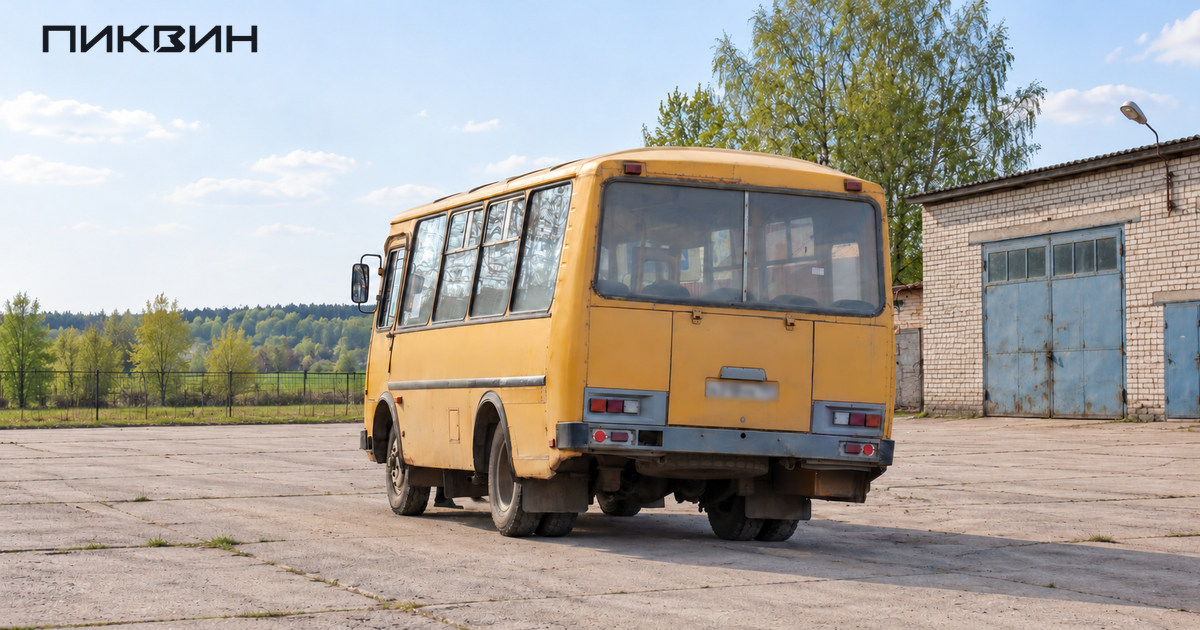 Жёлтый ПАЗ-32053 стоит на свободной площадке у автобусного депо, вид сзади в три четверти.