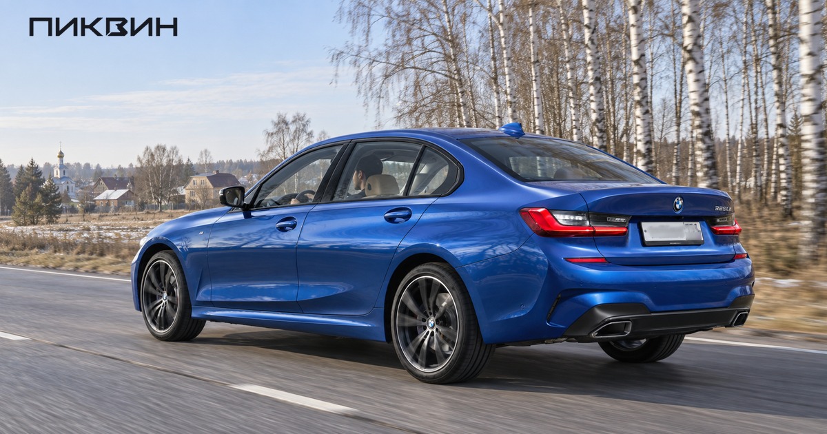 Синий BMW 325Li едет по загородной дороге, водитель находится слева.