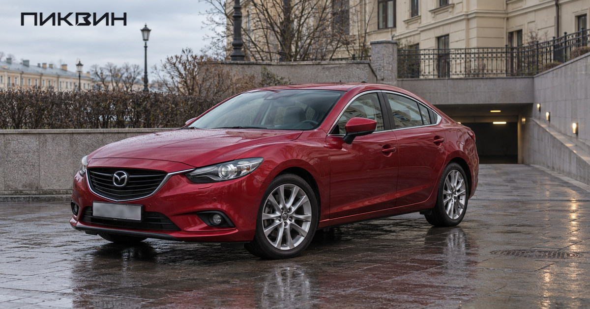 Красная Mazda6 Atenza стоит на ровной площадке перед въездом в подземный паркинг в Петербурге.